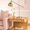 Emil side table styled in a living room next to pink velvet sofa with brass lamp and decorative items