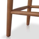 Close-up of wood bar footrest connecting tapered stool legs