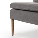 Macro close-up of banquette's seat cushion edge and wood leg junction