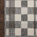 Overhead close view of rug corner showing detailed block pattern on a wood floor
