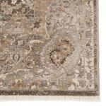 Close-up of rug corner highlighting intricate floral and geometric motifs with gold and taupe hues