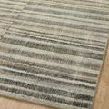 Corner view of Humphrey Natural Moss rug highlighting striped pattern and edge binding over wooden floor