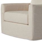 Close-up angle of cushioned backrest meeting squared armrest covered in oatmeal slipcover