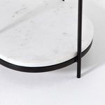 Close-up of edge where polished marble shelf meets powder-coated grey iron frame