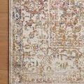 Close-up of Indra Ivory / Multi rug corner on wood floor highlighting delicate multi-color distressed design