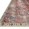 Low-angle close-up showing the rug’s texture and cream floral border with blue accents.