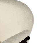 Side corner macro showing padded armrest seam and surrounding boucle material