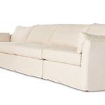 Angled side view focusing on arm curve, seat cushions, and matching accent pillow