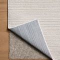 Rug corner flipped up to reveal textured underside and layered padding beneath