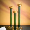 Three lit candle holders grouped together casting ambient shadows on warm wall