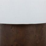 Lower part of the lamp showing the contrast between white fabric shade edge and textured burl wood base