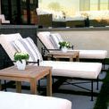 Two Provence Chaises on patterned grass and stone patio with wood side tables and striped pillows