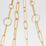 Detailed view of interconnected paperclip and round links in aged brass chain