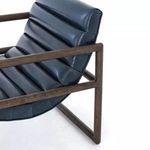 Close angle showing side contours of cushioned seat and back with wood frame