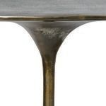 Close-up of slender stem and underside of smooth oval tabletop showing antique bronze patina
