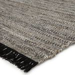 Close-up of textured weave and black fringe highlighting PET yarn material and color variation.