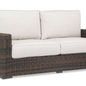 Montecito Loveseat in rich Cognac multi-colored resin wicker with cream cushions, designed for sophisticated outdoor living
