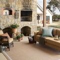 Easton Wheat Ivory Rug displayed in outdoor patio setting with wicker furniture and stone fireplace