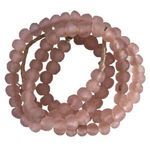 Close-up view of coiled blush pink sea glass beads with translucent matte texture