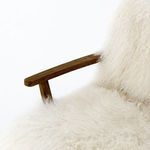 Armchair shown front on with accent lighting highlighting soft curly fur texture