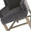 Close-up of seat cushion and armrest texture with visible wood leg angles and stretchers