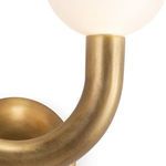 Close-up of curved brass arm smoothly transitioning into the right side globe with matte white glass