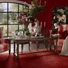 Emory Dining Table set in dining room with red walls, plaid wingback chairs, and decorative accessories