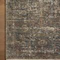 Detailed overhead close-up showing faded vintage motifs and frayed rug edges on wood floor