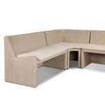 Close-up of cushioned seating corner section with curved rattan arms and beige fabric cushion