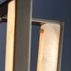 Detail view focusing on alabaster panel texture and brass fastener from side on Edgemere Pendant