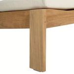 Close-up of ottoman leg showing natural teak wood grain and metal footpad