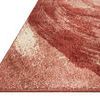 Close-up of rug corner showing rust and beige fiber texture and finished edge stitching