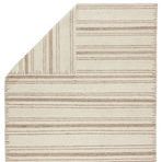 Back of rug partially folded over displaying reverse striping pattern in cream and brown hues
