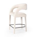 Rear angled view showing the sweeping back profile and metal footrest under soft fabric.