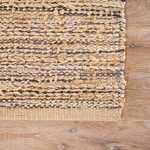 Close-up of edge of rug highlighting thick woven texture and layered fibers with mottled navy accents