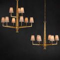 Two Goldfinch chandeliers hanging against dark wall, fitted with soft white fabric shades