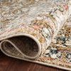 Rolled corner of beige rug highlighting dense pile and woven backing on hardwood floor