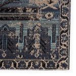 Close-up of the rug’s corner highlighting the intricate border trim woven in gray and blue.