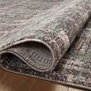 Folded edge reveals thin flatweave construction and underside texture of the rug