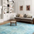 Loren Aqua Rug displayed in a living room with gray sofa, light walls, and modern decor