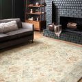 Rosette rug shown in cozy living room with gray sofa and black brick fireplace