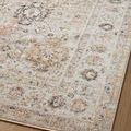 Close-up of rug edge and pattern detail showing muted multi-color design on wood floor