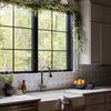 Kitchen sink front view featuring daisy planter, checkered towel, and leafy garland framing window above