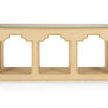 Cream colored raffia console table with gold accents and a clear tempered glass top, rectangular shape