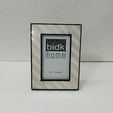 Frame standing upright against white textured surface and wall background