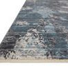 Angled low close-up of Samra Dove Sky Rug showing abstract pattern and short fringed edge on light background