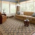 Judy Natural / Graphite Rug styled in sunlit living room with tan sofa, leather armchair, and floor lamp