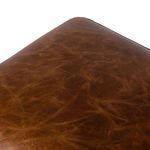 Close-up detail of ottoman smooth leather top with visible natural creases and patina
