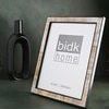 Resin Horn Picture Frame displayed upright on green surface with decorative black vase in background