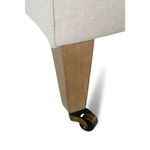 Close-up showing wooden tapered leg with antique brass caster wheel